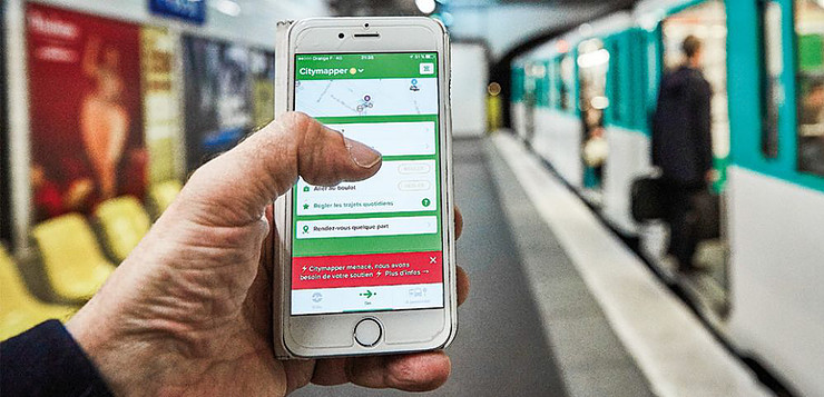 Un smartphone devant un métro avec une application d'horaire des transports